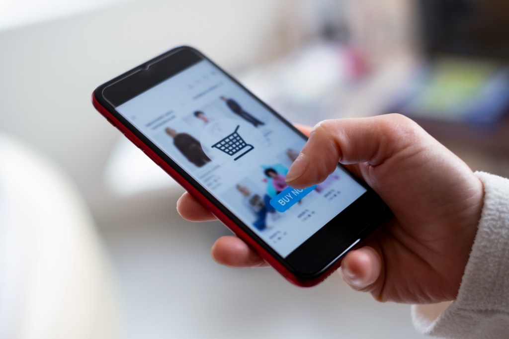 Person betreibt Online-Shopping auf dem Smartphone.