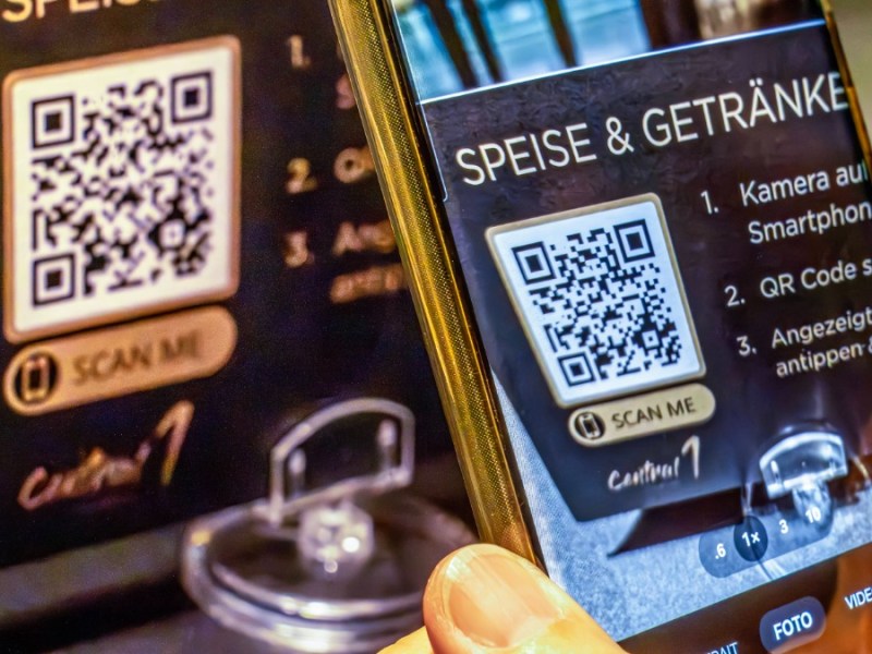 Gast im Restaurant scannt QR-Code mit seinem Handy