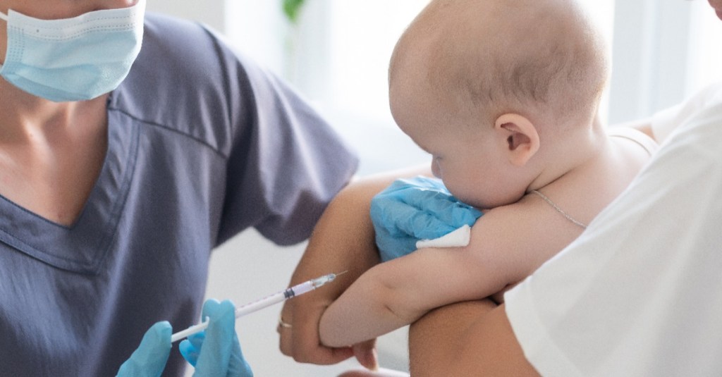 ein Arzt gibt einem kleinen Baby eine Spritze