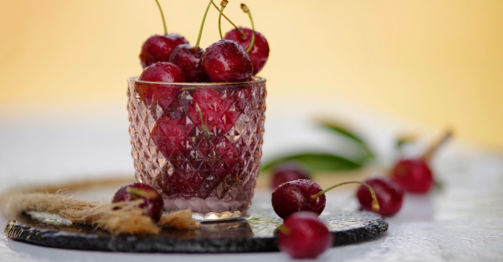 Frische rote knackige Kirschen auf dem Tisch im Glas