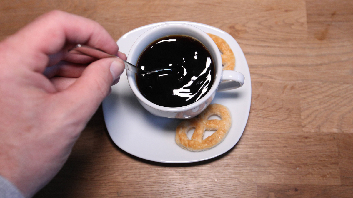 Kaffee in einer Kaffeetasse, Hand rü