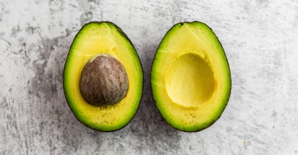 Avocado hat rote Flecken: eine halbierte Avocado mit einem kleinen roten Fleck