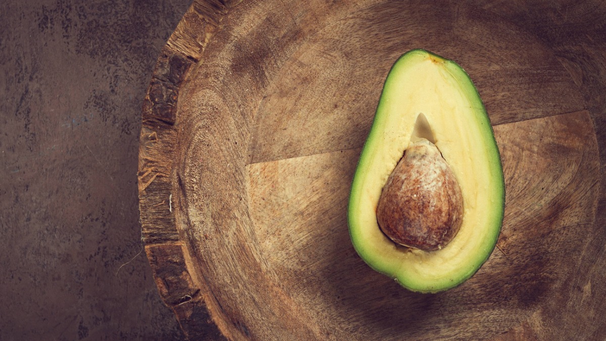 Avocado rote Flecken: eine Avocado liegt aufgeschnitten auf einem KÃ¼chenbrett