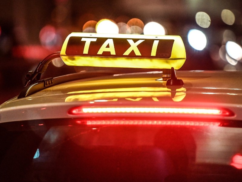 Taxifahrer: ein Taxi steht nachts an einer StraÃŸe