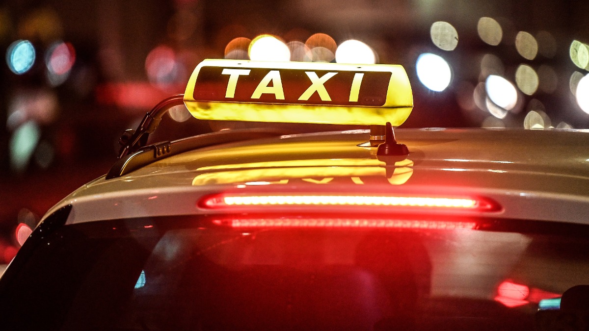 Taxifahrer: ein Taxi steht nachts an einer StraÃŸe