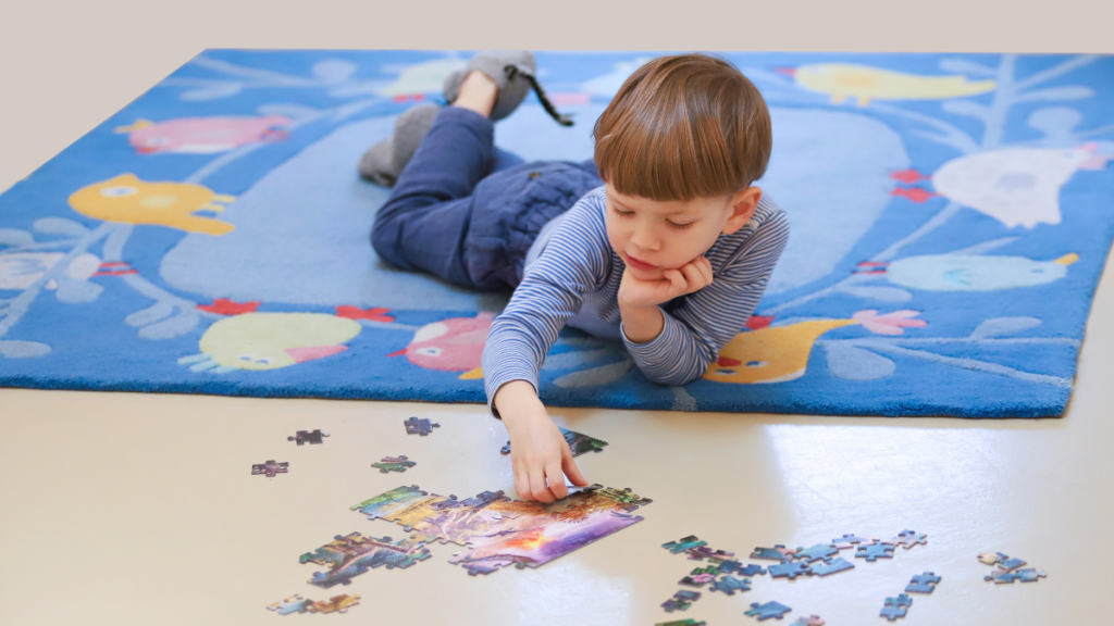 Junge puzzelt auf dem Boden