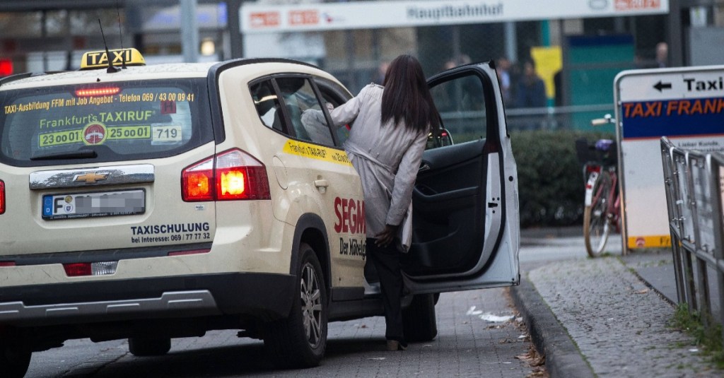 Taxifahrer: eine Frau steigt in ein Taxi ein