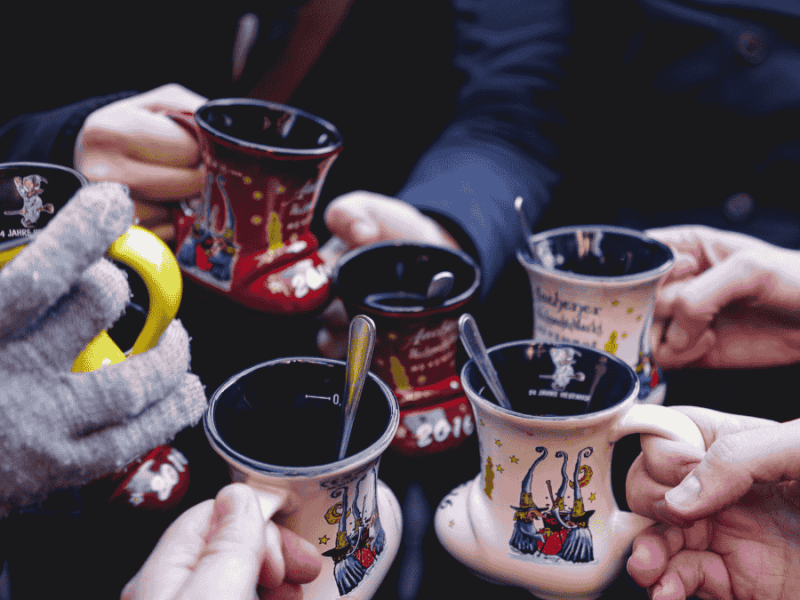 Weihnachtsmarkt, Leute stoÃŸen mit Punsch an.