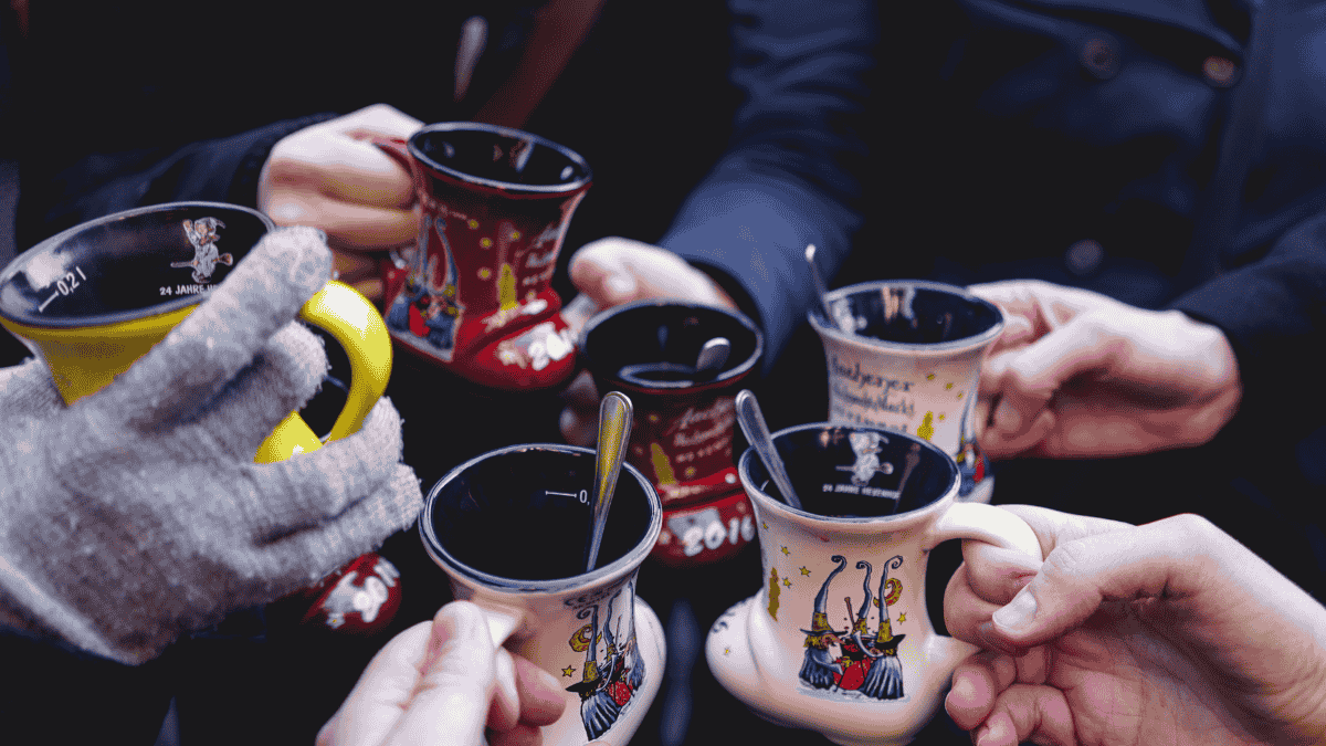 Weihnachtsmarkt, Leute stoÃŸen mit Punsch an.