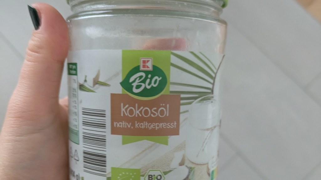 Ein Glas Bio-Kokosöl wird in die Kamera gehalten.