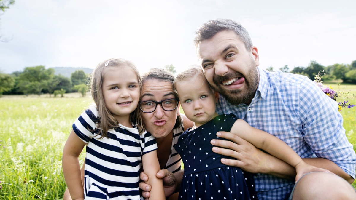 kreative Familienfotos: Vater, Mutter und zwei Kinder ziehen Grimassen fÃ¼r die Kamera