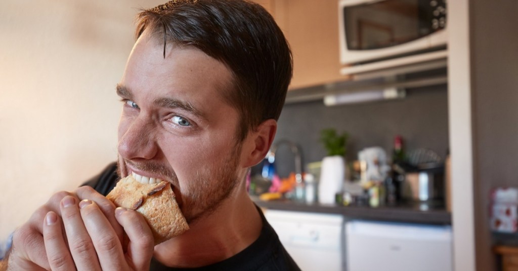 Misophonie: Mann beißt in ein Sandwich