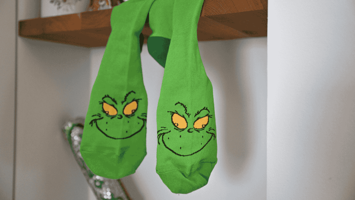 Weihnachtsmuffel, grÃ¼ne Grinch-Socken hÃ¤ngen vom Regal