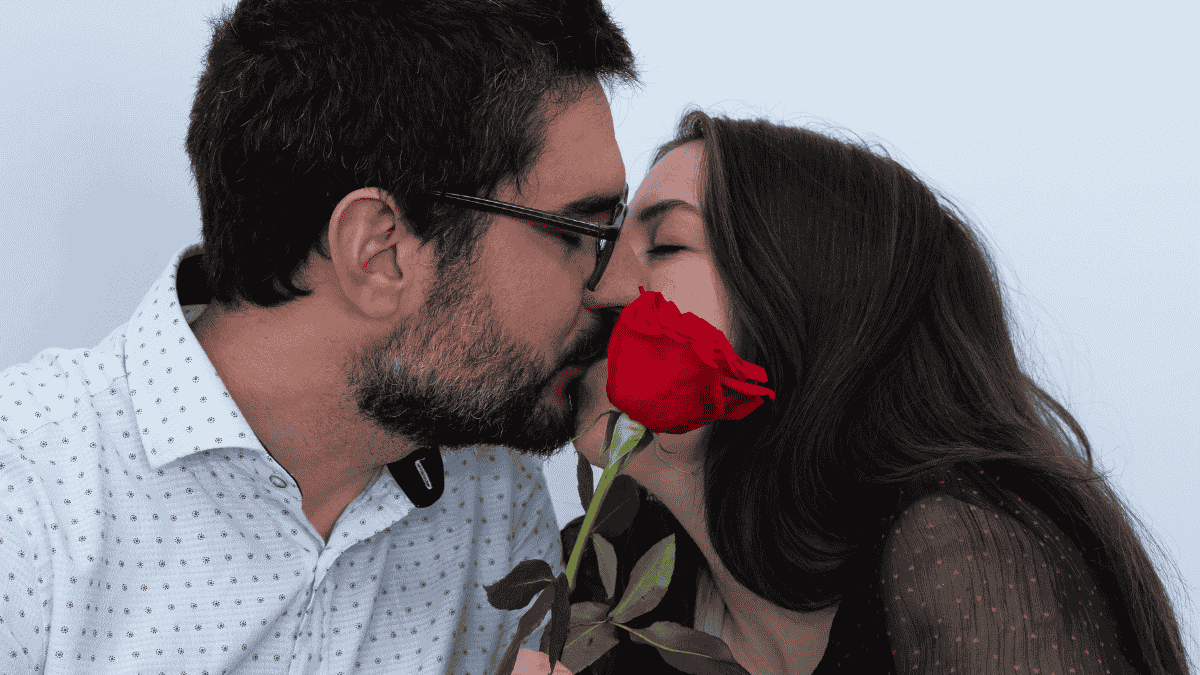 Valentinstag-Ideen, küssendes Paar mit roter Rose