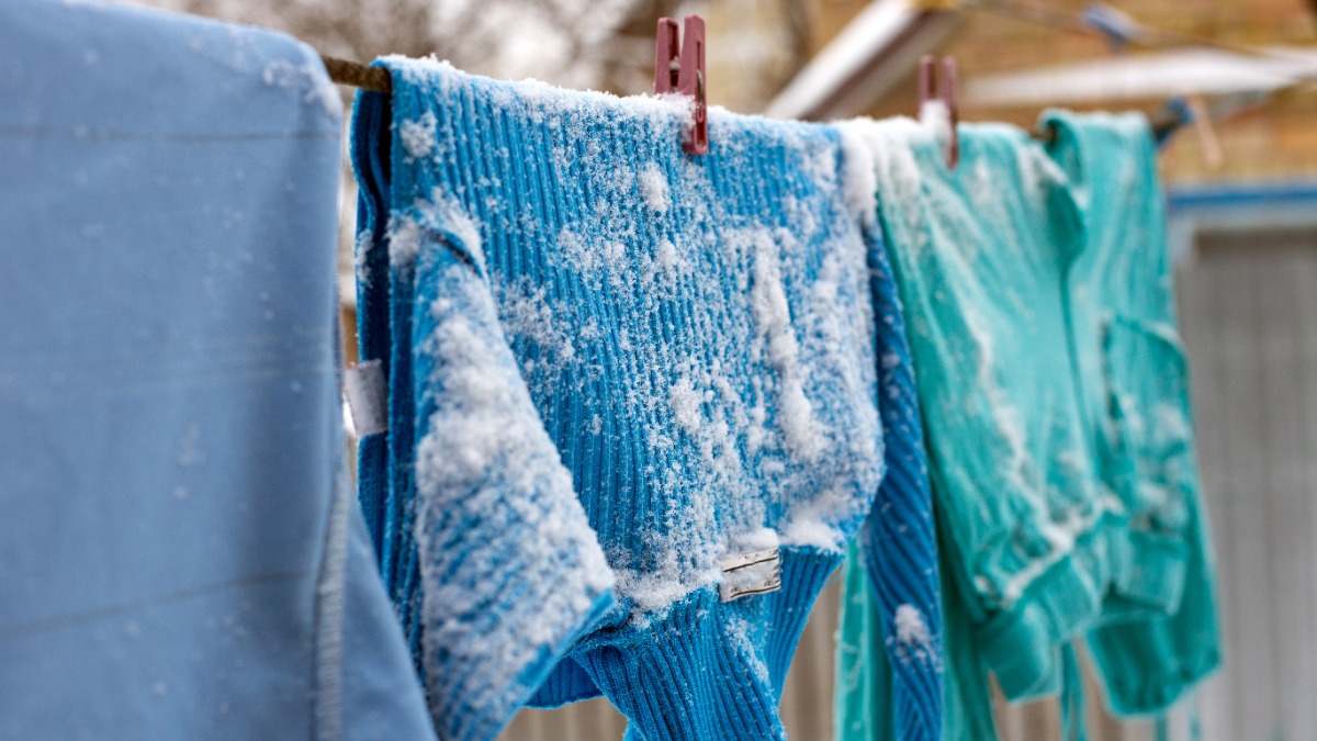 Wäsche im Winter draußen trocknen: Wäsche hängt auf einer Leine und ist mit Schnee bedeckt