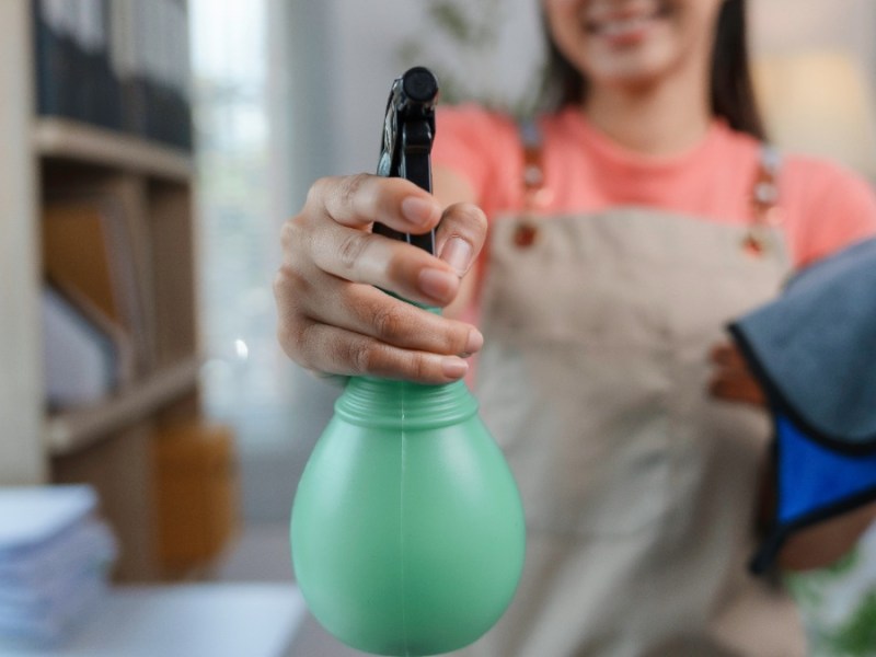 Cleanfluencer: eine Frau hält eine Sprühflasche in die Kamera