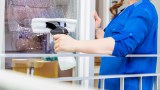 eine Frau reinigt ihre Fenster mit einem Fenstersauger