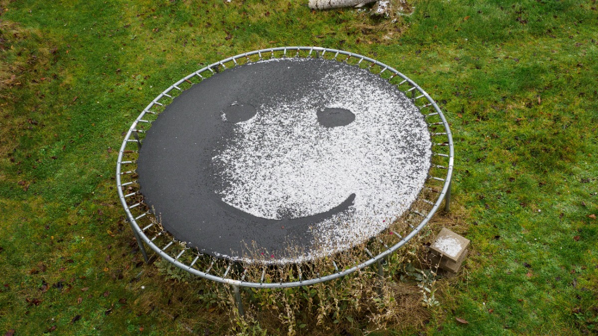 Trampolin reinigen: ein Trampolin mit angetautem Schnee auf dem Sprungtuch