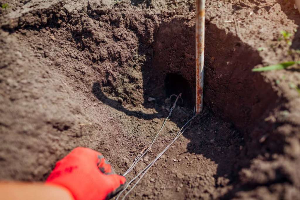 Ein Gärtner baut eine Falle, um Wühlmäuse zu bekämpfen.