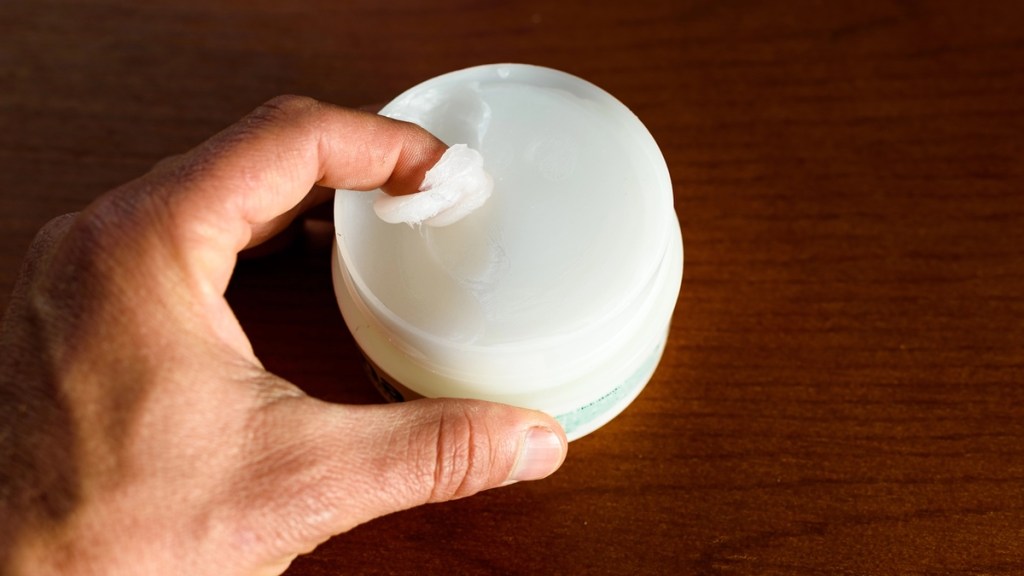Finger in einer Dose mit Vaseline.