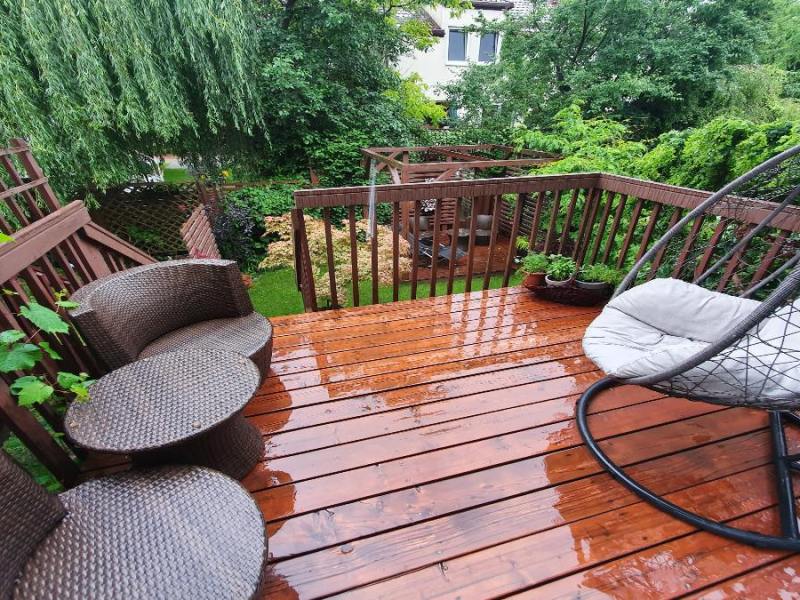 Ein verregneter Balkon mit Balkonmöbeln.
