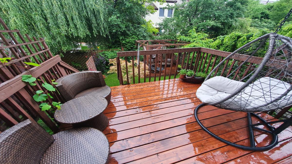 Ein verregneter Balkon mit Balkonmöbeln.
