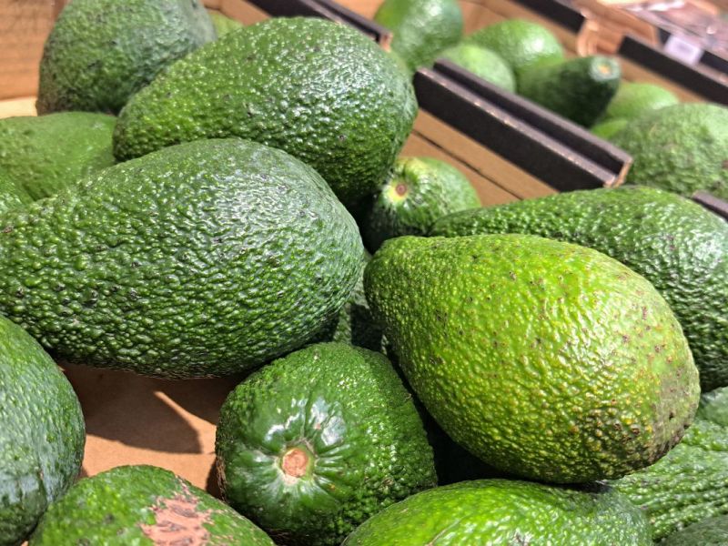 Ein Haufen grüner Avocados im Supermarkt
