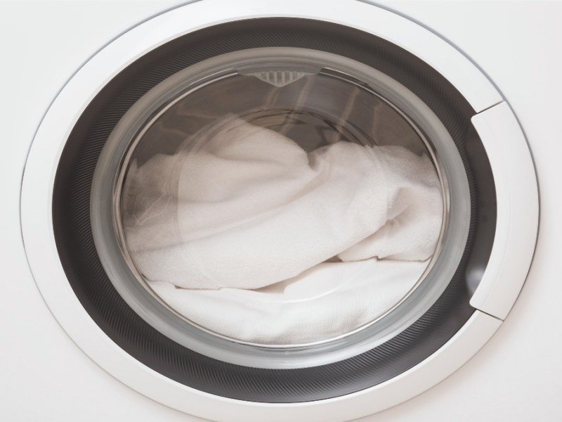 Eine Daunendecke wird gewaschen in einer Waschmaschine.