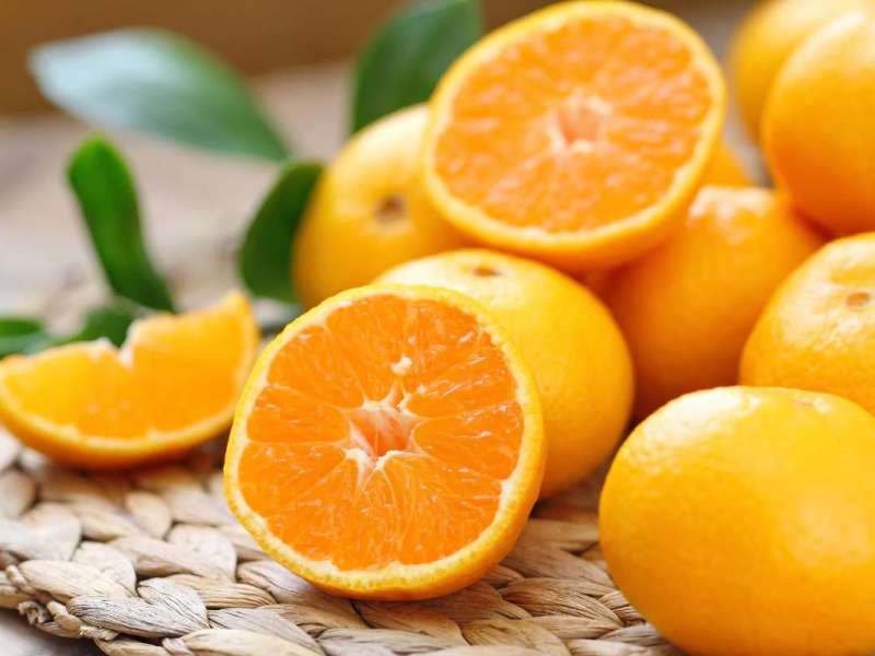 Gelbe frische Orangen auf einem Tisch.