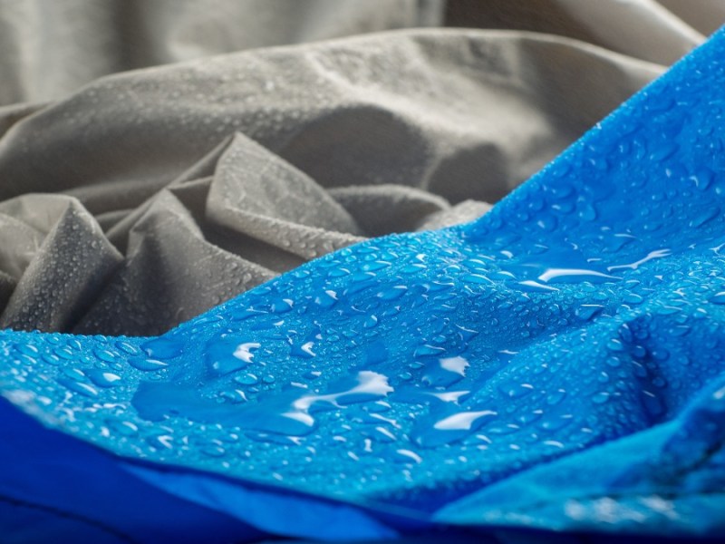 Eine blaue Regenjacke wird gewaschen.