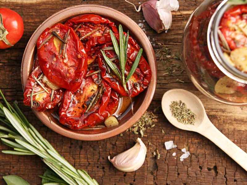 Eine Schüssel mit getrockneten Tomaten und Olivenöl steht auf einem Tisch.