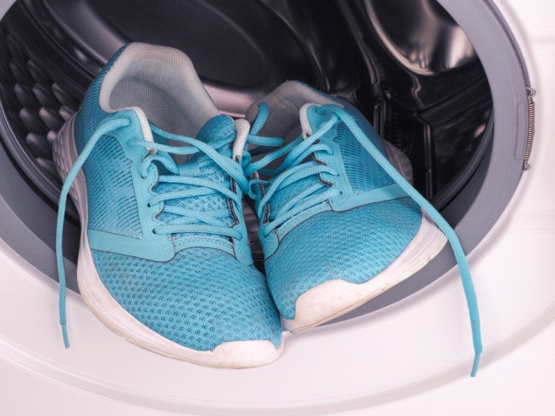 Ein paar hellblaue Turnschuhe in einer Waschmaschine.