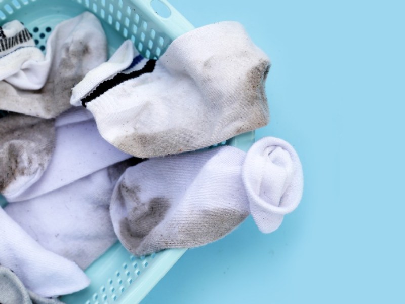 schmutzige weiße Socken in einem Wäschekorb