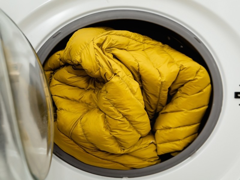 Eine gelbe Winterjacke in einer Waschmaschine.