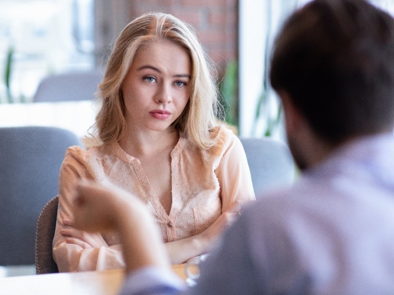 Gelangweilte Frau beim Date mit einem Mann im Cafe