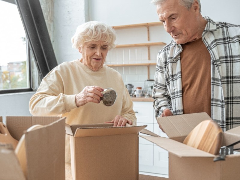 zwei Senioren packen Kisten ein