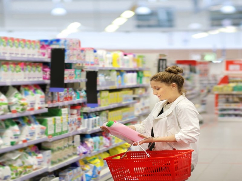 Eine Frau kauft Waschmittel im Supermarkt.